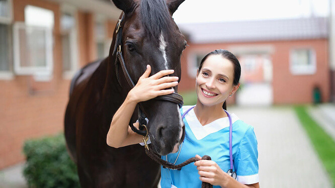 woman vet smiling with a horse